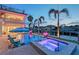 Beautiful backyard pool and spa with lighting, a dock, and waterfront views at 571 Birdie Ln, Longboat Key, FL 34228