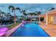 Beautiful backyard pool and spa with lighting, a dock, and waterfront views at 571 Birdie Ln, Longboat Key, FL 34228