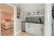 Wet bar featuring elegant gray cabinets, mosaic backsplash, and view into adjacent bedroom at 571 Birdie Ln, Longboat Key, FL 34228