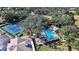 Aerial view showcasing the community pool, tennis courts, and lush green surroundings at 5803 Garden Lakes Palm, Bradenton, FL 34203