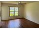 Bright bedroom with ceiling fan, wood floors, and a window overlooking a serene view at 5803 Garden Lakes Palm, Bradenton, FL 34203