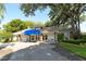 Inviting home with a blue awning, lush landscaping and benches for relaxing outdoors at 5803 Garden Lakes Palm, Bradenton, FL 34203
