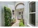 Front door is framed by an arched brick entryway and verdant landscaping at 5803 Garden Lakes Palm, Bradenton, FL 34203