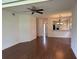 Open-concept living room with hardwood floors, ceiling fan, and a view into the foyer and kitchen at 5803 Garden Lakes Palm, Bradenton, FL 34203