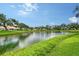 Peaceful lake view surrounded by mature trees and community homes on a clear day at 5803 Garden Lakes Palm, Bradenton, FL 34203