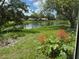 Scenic view from inside home of pond, flowers, and lush green space at 5803 Garden Lakes Palm, Bradenton, FL 34203