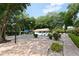 Community pool area surrounded by lush greenery, tables, chairs, and a covered seating area at 5803 Garden Lakes Palm, Bradenton, FL 34203