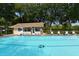 Large community pool with clear blue water and ample lounge seating near the pool house at 5803 Garden Lakes Palm, Bradenton, FL 34203