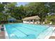 Inviting community pool with ample lounge seating, a pool house, and a covered seating area at 5803 Garden Lakes Palm, Bradenton, FL 34203