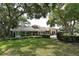 Expansive rear of home with wall of windows overlooking lush green lawn and mature trees at 5803 Garden Lakes Palm, Bradenton, FL 34203