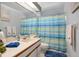 Bright bathroom featuring a large mirror, vanity with sink, and shower with a colorful striped curtain at 6065 Marella Ct, Sarasota, FL 34243