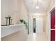 Hallway featuring tiled floor, hanging pendant lights, and a decorative shelf with plant at 6065 Marella Ct, Sarasota, FL 34243