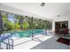 Beautiful screened-in pool with an outdoor dining table surrounded by lush landscaping at 6065 Marella Ct, Sarasota, FL 34243