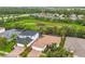 Aerial view of property with lush tropical landscaping, screened-in lanai, and paver driveway at 616 Dogwood Run, Bradenton, FL 34212