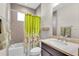 Bathroom with shower-tub combo, neutral tiled walls, and a floral shower curtain at 616 Dogwood Run, Bradenton, FL 34212