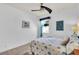 Bedroom with ceiling fan, neutral walls, a window with blue curtains, and coastal-themed decor at 616 Dogwood Run, Bradenton, FL 34212