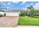 Well-maintained three car garage home with paver driveway, lush landscaping, and screened in entryway at 616 Dogwood Run, Bradenton, FL 34212