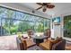 Inviting screened-in lanai area with comfortable seating surrounding a cozy fire pit and mounted television at 616 Dogwood Run, Bradenton, FL 34212