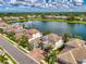 Waterfront home featuring a clay tile roof and mature landscaping at 6318 Rivo Lakes Blvd, Sarasota, FL 34241