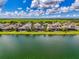 Aerial view of waterfront houses in a community, featuring lakes and lush green backyards under a partly cloudy sky at 6318 Rivo Lakes Blvd, Sarasota, FL 34241