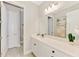 Well-lit bathroom with a dual-sink vanity, a large mirror, and a view into a separate toilet room at 6318 Rivo Lakes Blvd, Sarasota, FL 34241
