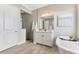 Modern bathroom featuring a soaking tub, stylish vanity, and a glass-enclosed shower at 6318 Rivo Lakes Blvd, Sarasota, FL 34241