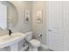 Stylish half bathroom featuring a pedestal sink, elegant fixtures, and tasteful wall decor at 6318 Rivo Lakes Blvd, Sarasota, FL 34241