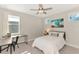 Bright bedroom featuring a desk area, wave art, and modern ceiling fan at 6318 Rivo Lakes Blvd, Sarasota, FL 34241