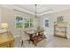Bright dining room featuring a wood table, neutral chairs, bench and a picturesque view of the outdoors at 6318 Rivo Lakes Blvd, Sarasota, FL 34241