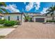Beautiful two-story home featuring a brick driveway and lush landscaping at 6318 Rivo Lakes Blvd, Sarasota, FL 34241