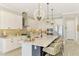 Bright kitchen features white cabinets, stainless appliances, granite countertops, a tile backsplash, and island seating at 6318 Rivo Lakes Blvd, Sarasota, FL 34241