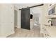 Modern kitchenette featuring a microwave and sink next to a sliding barn door leading to another room at 6318 Rivo Lakes Blvd, Sarasota, FL 34241