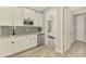 Modern kitchenette with white cabinets, a subway tile backsplash, and stainless steel appliances, conveniently located near bedroom at 6318 Rivo Lakes Blvd, Sarasota, FL 34241