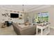 Spacious living room featuring custom built-ins and sliding glass doors to outdoor pool at 6318 Rivo Lakes Blvd, Sarasota, FL 34241