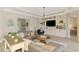 Bright living room featuring a large sectional, custom built-ins, and wood-look tile flooring at 6318 Rivo Lakes Blvd, Sarasota, FL 34241