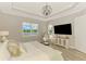 Spacious main bedroom featuring a waterfront view, massage chair, and a stylish cabinet at 6318 Rivo Lakes Blvd, Sarasota, FL 34241