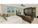 Bright main bedroom featuring water views, dark wood armoire, desk area, and modern ceiling fan at 6318 Rivo Lakes Blvd, Sarasota, FL 34241