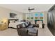 Spacious main bedroom suite with a dark leather sectional, large windows, and scenic water views at 6318 Rivo Lakes Blvd, Sarasota, FL 34241
