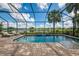 Relaxing screened-in pool area with a tranquil view of a lake and lush greenery, perfect for enjoying the outdoors at 6318 Rivo Lakes Blvd, Sarasota, FL 34241
