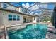 A luxurious screened-in pool is surrounded by brick pavers, string lights, and manicured landscaping, creating a serene outdoor oasis at 6318 Rivo Lakes Blvd, Sarasota, FL 34241