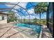 Refreshing pool in a screened enclosure with a spa, surrounded by lush landscaping and lake scenery at 6318 Rivo Lakes Blvd, Sarasota, FL 34241