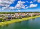 This waterfront home features a screened lanai, a sparkling pool, and lush tropical landscaping at 6318 Rivo Lakes Blvd, Sarasota, FL 34241