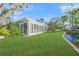 Back exterior view featuring glass windows and sliding doors that capture views of the waterfront at 655 Spanish Way, Longboat Key, FL 34228