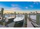 Private boat dock featuring multiple boat slips with power and bumpers on a sunny day at 655 Spanish Way, Longboat Key, FL 34228
