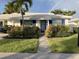 Charming home with a white exterior, blue trim, well-maintained landscaping, and a rainbow in the sky at 655 Spanish Way, Longboat Key, FL 34228