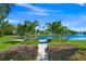 A walkway lined with green vegetation leading to a bench overlooking a canal at 655 Spanish Way, Longboat Key, FL 34228