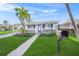Charming single-story home with blue shutters, a palm tree, and a well-manicured lawn at 655 Spanish Way, Longboat Key, FL 34228