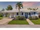 Charming single-story home with well-manicured landscaping, blue shutters, and matching trim at 655 Spanish Way, Longboat Key, FL 34228