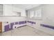 White cabinetry, backsplash features, and updated drywall are featured in the kitchen renovation at 655 Spanish Way, Longboat Key, FL 34228