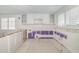 Partially renovated kitchen with white cabinetry, updated drywall, and tile flooring at 655 Spanish Way, Longboat Key, FL 34228